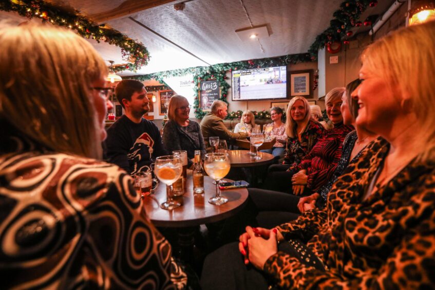 The Fisherman's Tavern is busy with staff from Jarvis Opticians sitting around three tables and celebrating their Christmas night out. 