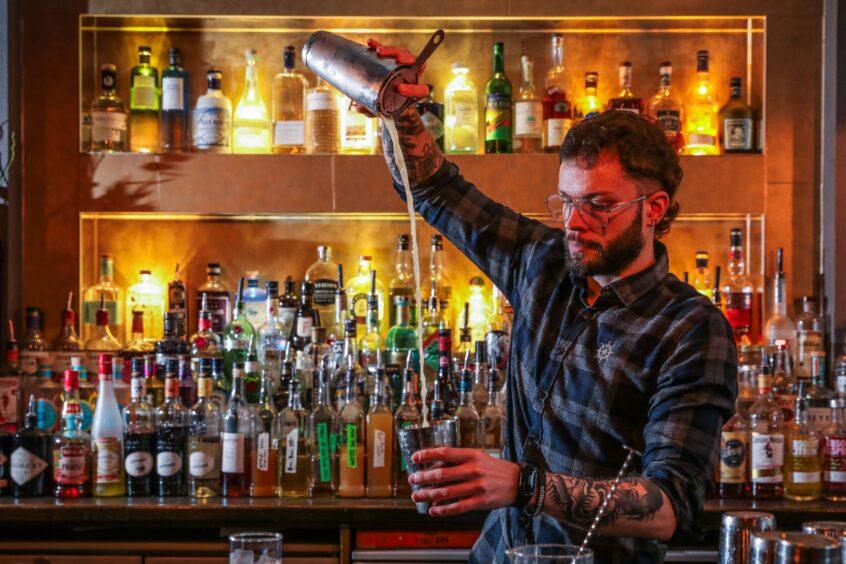 Daniel Gora, general manager at Bruach, pours a cocktail. 