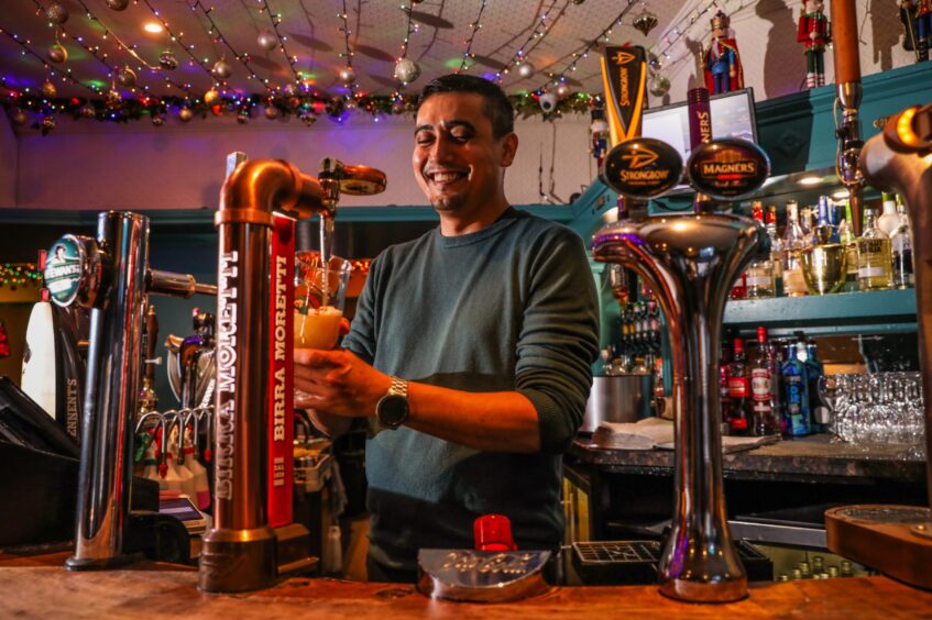 Smiling bartender Malcolm Kane pours a pint in The Anchor. 