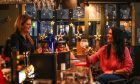 Manager Marta Raynor chats with Gayle while she stands behind the bar at The Keys Bar in St Andrews.