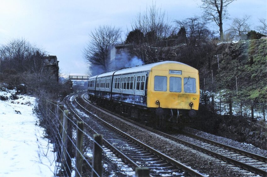 The Class 101 unit at Barnhill, beside an embankment