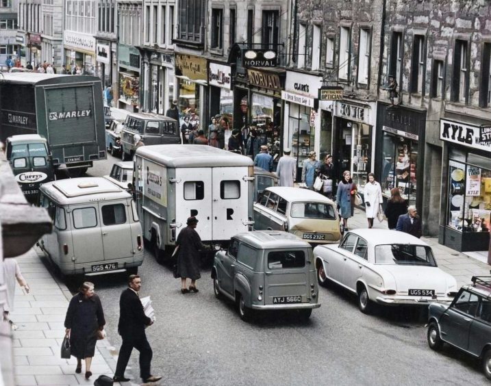 a busy street scene with pedestrians and vehicles