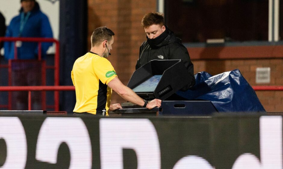 Referee Steven McLean checks VAR before awarding Dundee a penalty 