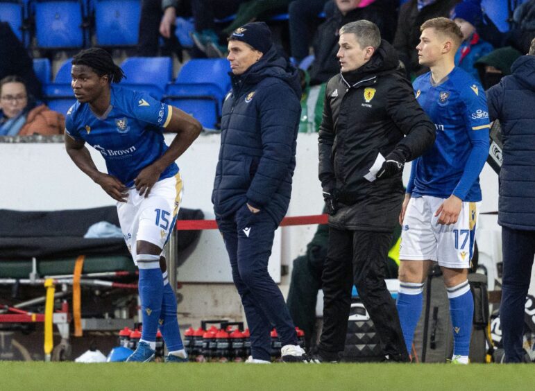 Aaron Essel stands beside manager Simo Valakari on the sidelines waiting to come on for St Johnstone as a substitute.