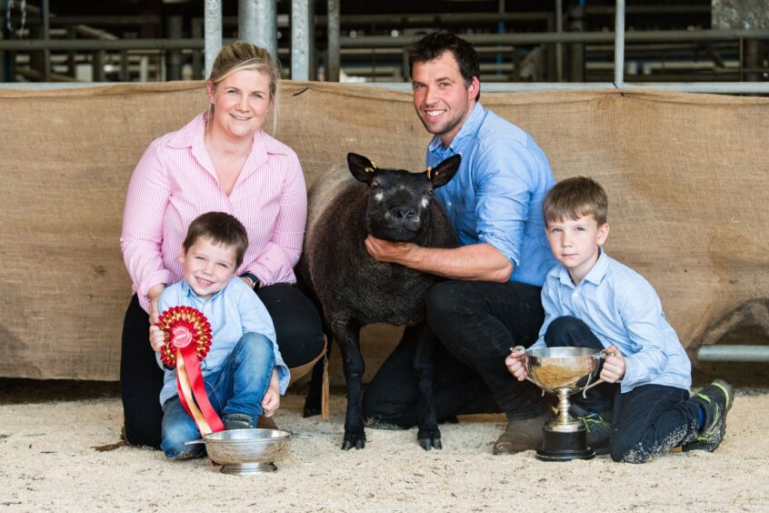 Perthshire wedding photographer Eilidh Robertson with her own family, a sheep, trophies and rosette