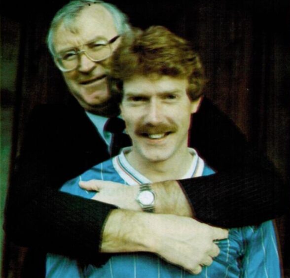 MacKay, wearing a Rangers top, gets a hug from Gers boss Jock Wallace after retiring from the game.