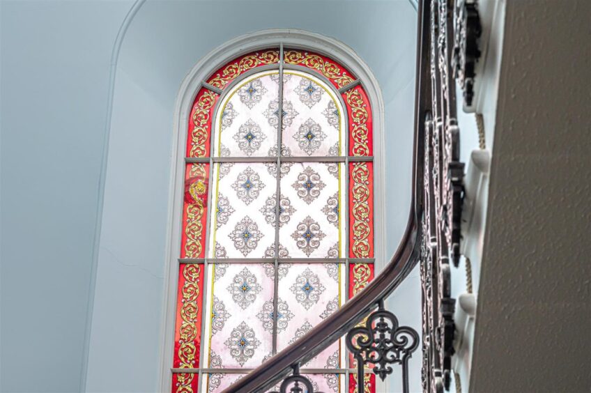 Patterned window overlooking the landing.