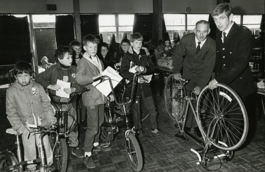 Police constables John Davie and Eric Jeffrey with some youngsters who took their bikes along to the "Code-a-bike '85" scheme in Dundee.