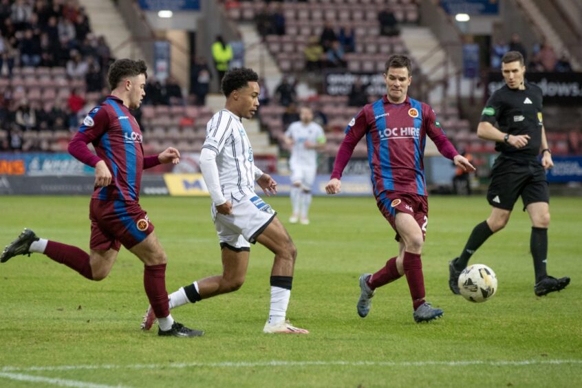 Kane Ritchie-Hosler gets a pass away under pressure from two Stenhousemuir opponents.