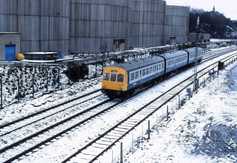 A Class 101 diesel unit is about to pass under Roodyards Bridge during a late flurry of snow at Carolina Port on March 30 1985.