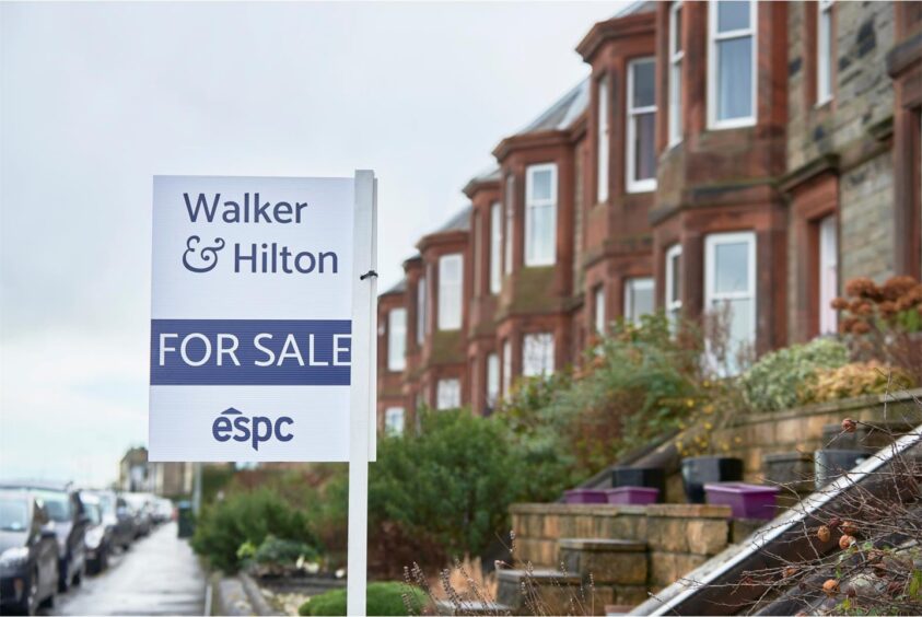 A For Sale sign in a garden of a terraced house, with Dunfermline house prices on the rise 