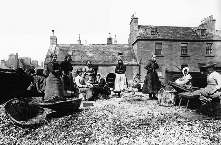 fisher folk on Fisher Street in Broughty Ferry, with baskets/creels nearby