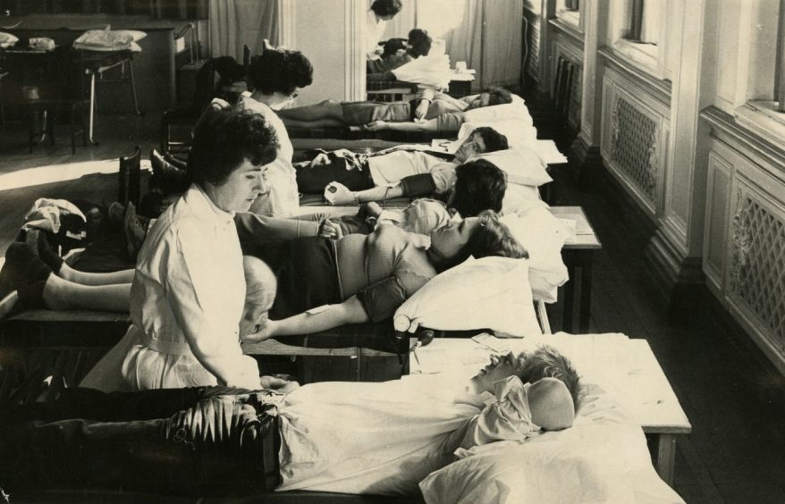 a row of people lying on beds for blood donation at the Marryat Hall, Dundee, in January 1975.