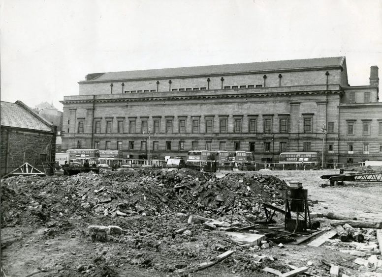 a pile of rubble that was the former bus stance in Dundee, with the Caird Hall in the background