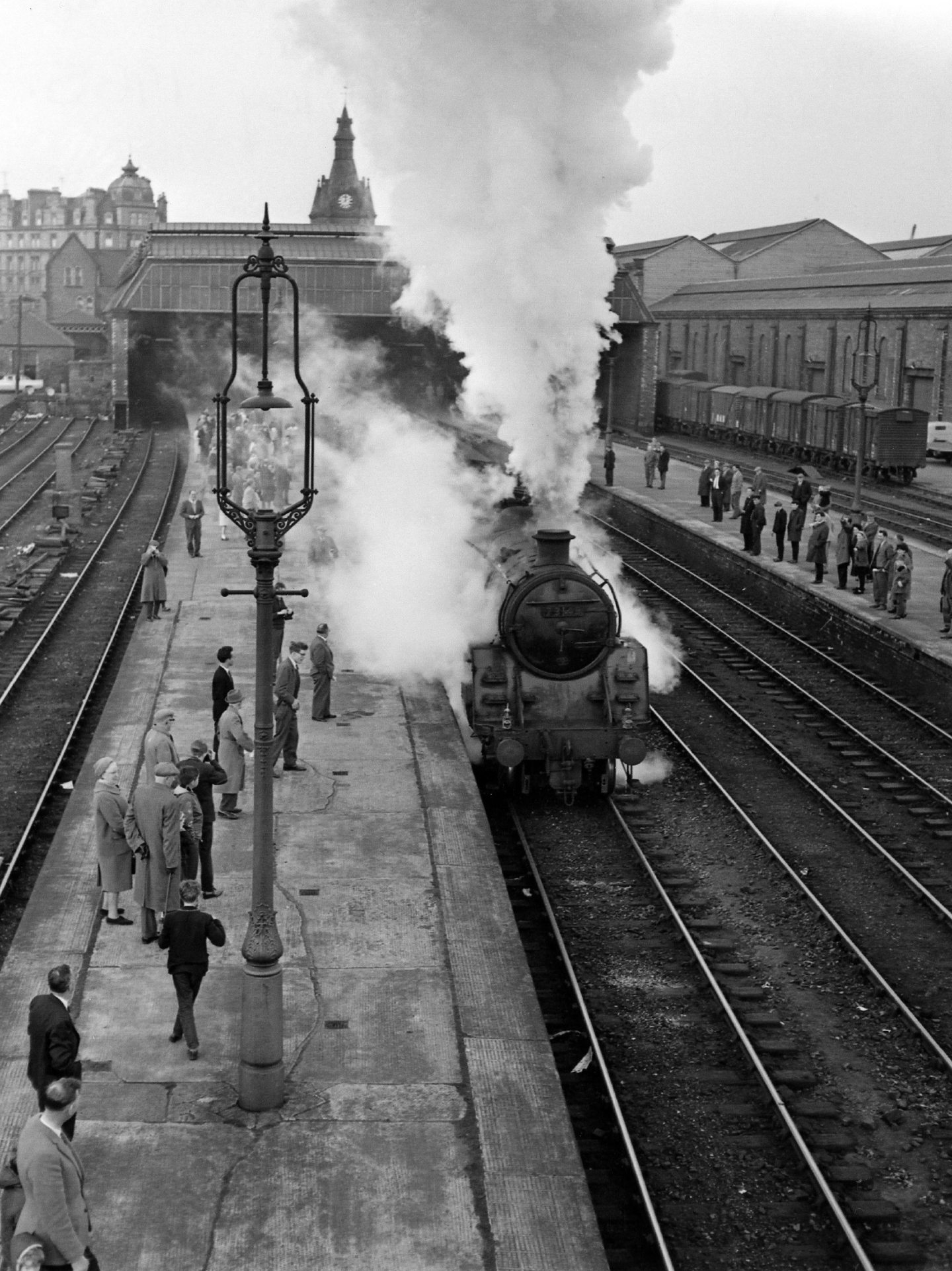 people stand on the platforms and steam rises into the air as the last train leaves from Dundee West Station in 1965. 