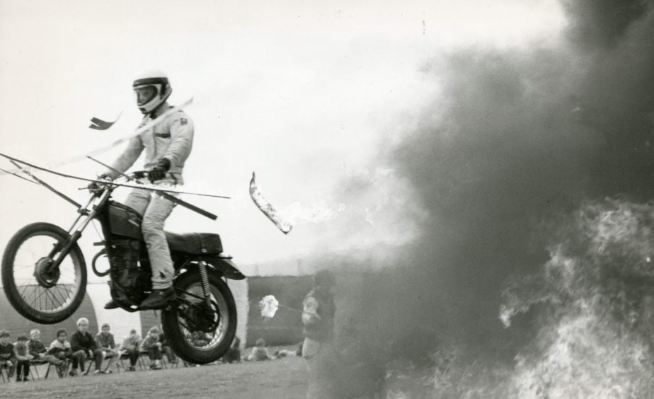 a stunt rider jumps on his bike through the flames