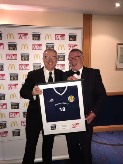 Jim receiving a framed Scotland strip. 