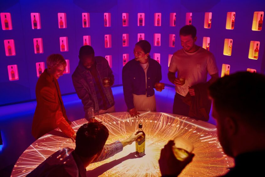 People drinking around an illuminated table as they take part in Journey of Flavour