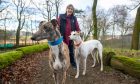 Greyhound Rescue Fife owner Celia Fernie walking two dogs.