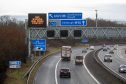 Gantry signs on the M90 tell motorists about the red weather warning in place for parts of Fife and Stirling. Image: Kenny Smith/DC Thomson