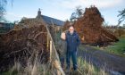 Liz Lasota and Robert Neilson returned home to discover  that 50ft trees had missed their home by metres. Image: Kenny Smith/DC Thomson