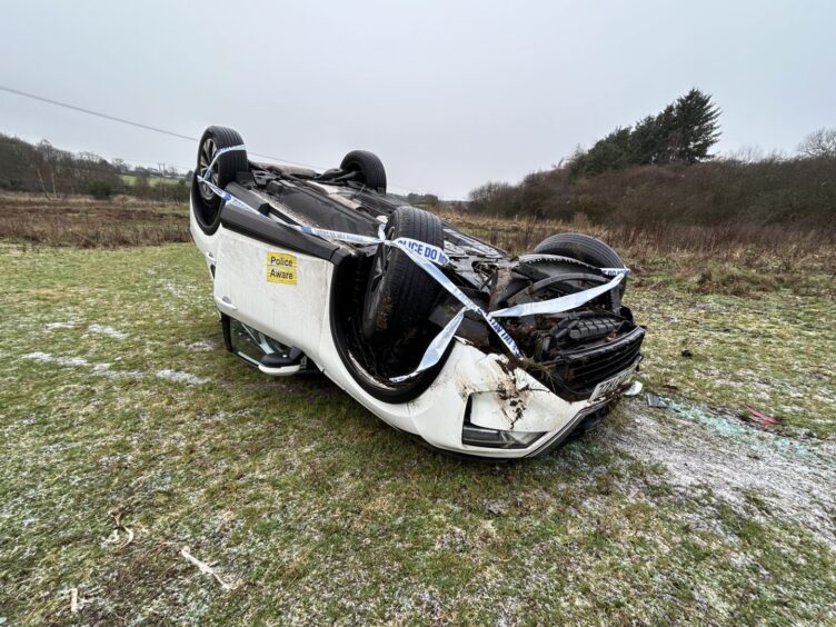 The car landed on its roof in a field.