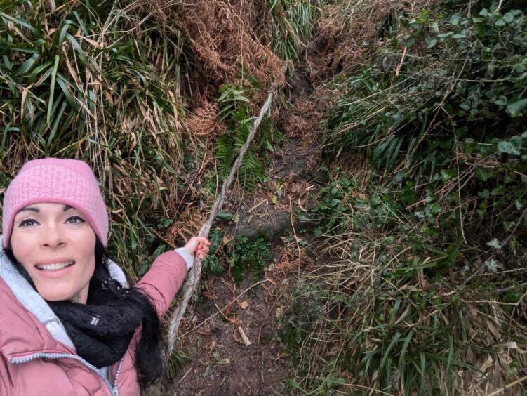 Gayle hauls herself up to the cave using this rope.