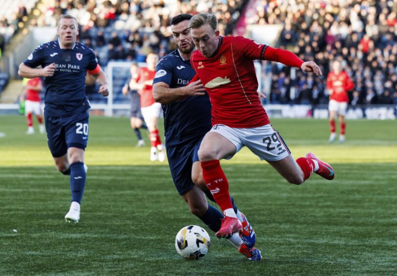 Raith Rovers defender Jordan Doherty challenges Falkirk's Calvin Miller.