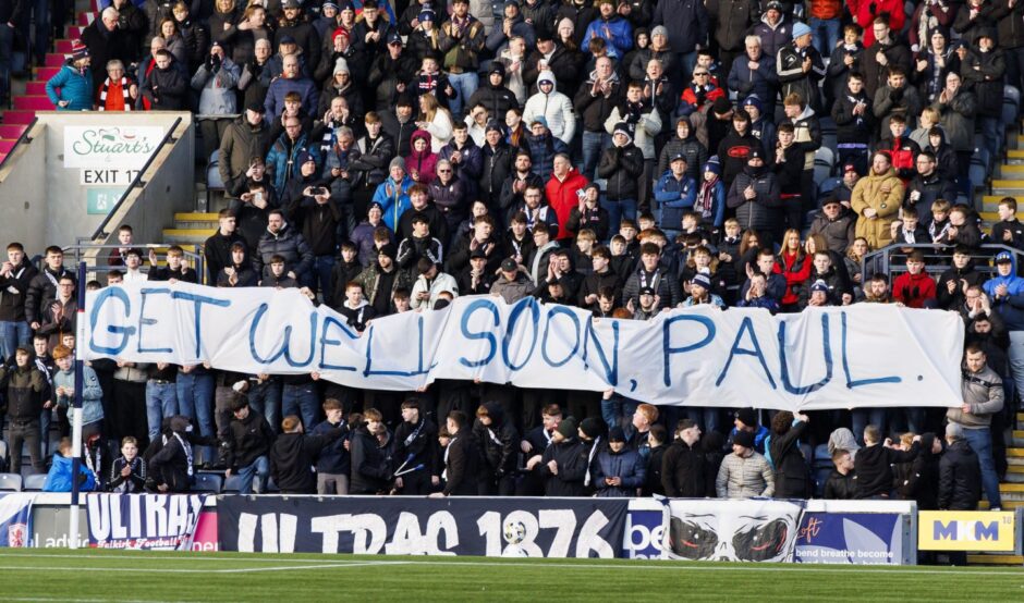 A banner held up by Falkirk fans says, 'get well soon, Paul'.