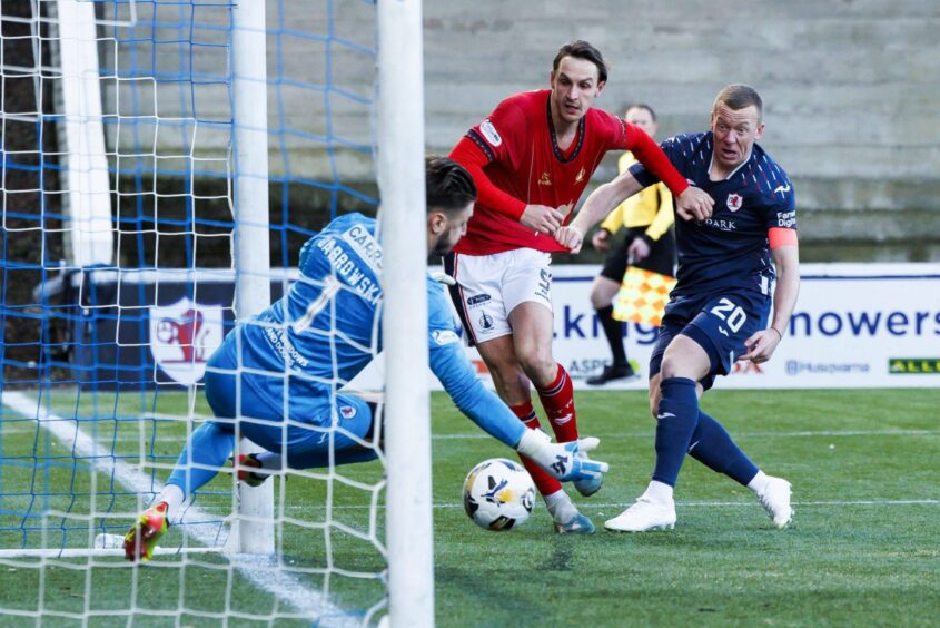 Liam Henderson heads past Kevin Dabrowski for Falkirk's opening goal against Raith Rovers.