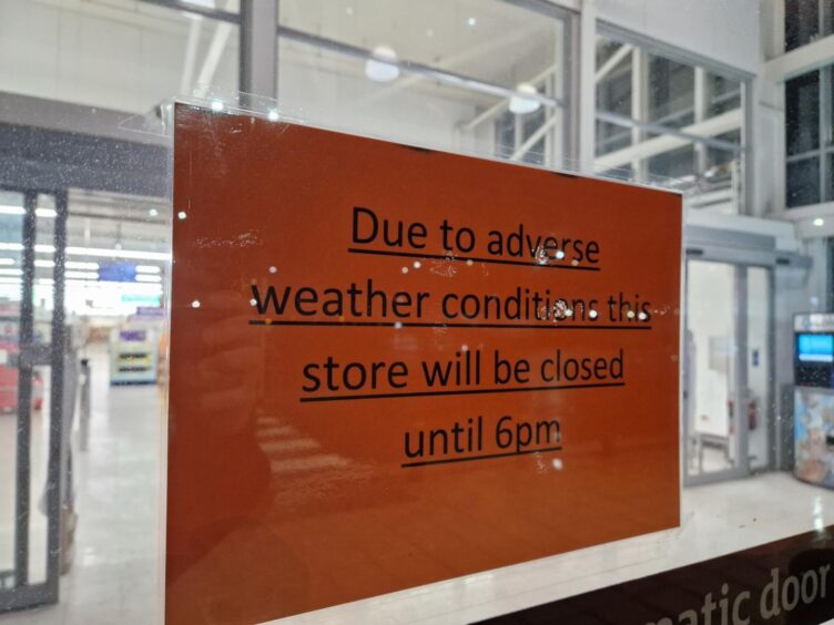 A sign on the glass door indicating that the Dundee Sainsbury's is shut until 6pm due to storm Eowyn