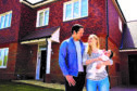 young family with baby standing outside their home