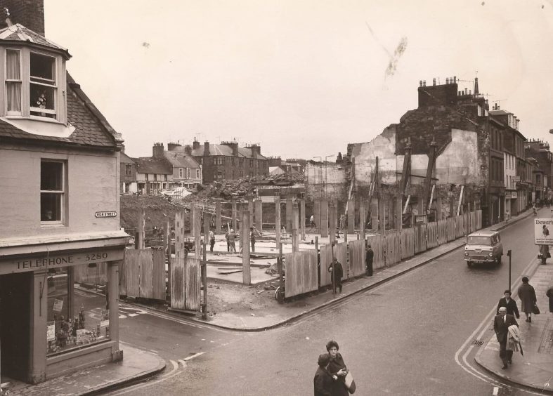 an elevated view showing work starting at the site of the Oriental Bar in 1969, as people walk by 