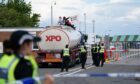 Police officers watch as protesters from This Is Rigged sit on top of an oil tanker at the Ineos refinery in Grangemouth, Fife in Scotland. Picture date: Wednesday July 19, 2023. Image: PA