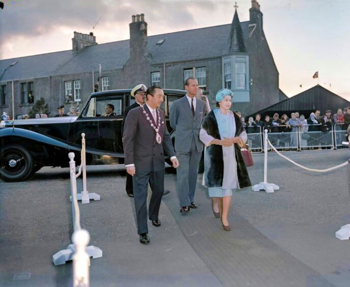 The Queen and Duke of Edinburgh in Perth, with crowds in the background