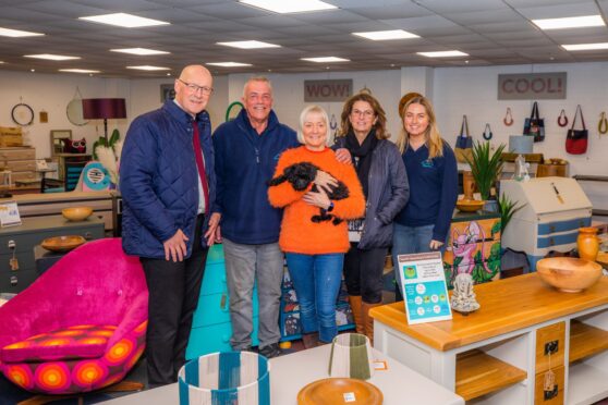 John Swinney with group of people inside Tayside Upcycling and Craft Centre showroom filled with upcycled furniture