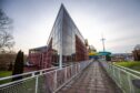 Perth leisure pool exterior, an angular glass building with flumes and walkway leading up to it