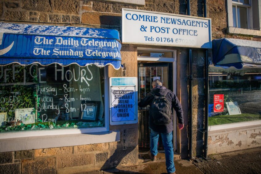 Man walking into building with sign above door which reads 'Comrie newsagents and post office'