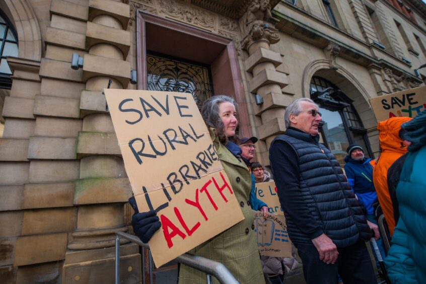 Woman with 'save rural libraries Alyth' written on large piece of cardboard