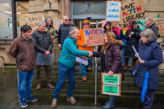 Councillor Jack Welch on steps of Perth and Kinross HQ accepting petition from group of people with save our libraries placards