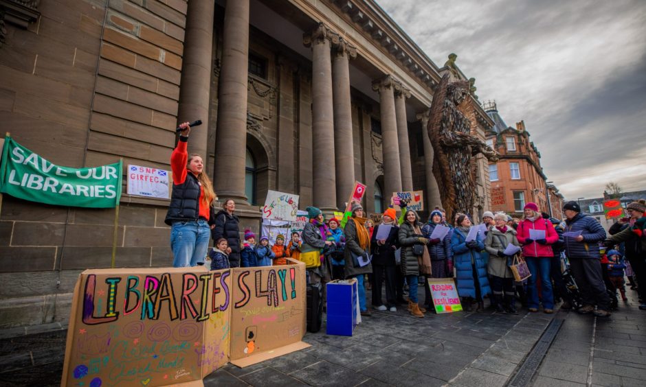 Woman with upraised fist addressing crowd outside Perth Museum