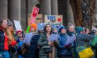 Group of people with 'save our library' placards outside Perth Museum