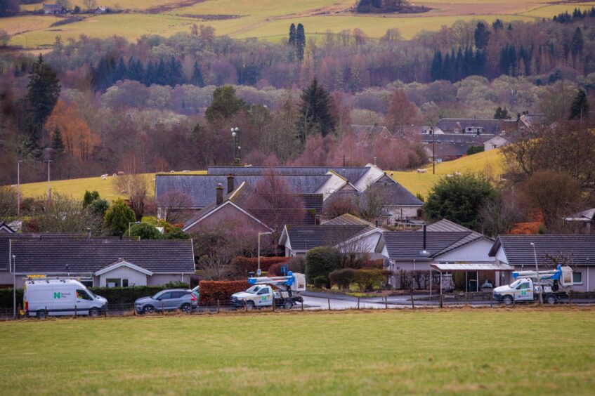 Power company cans parked next to Duff Avenue, Moulin, with Pitlochry countryside behind.