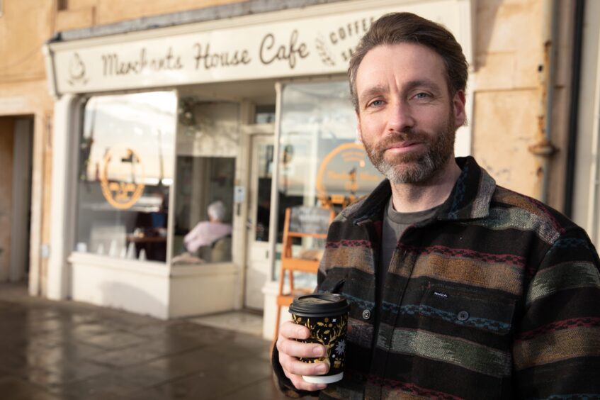 Image shows: The Scottish Surfer, Scott Mitchell, outside his favourite coffee stop, Merchant's House Coffee in Kirkcaldy.