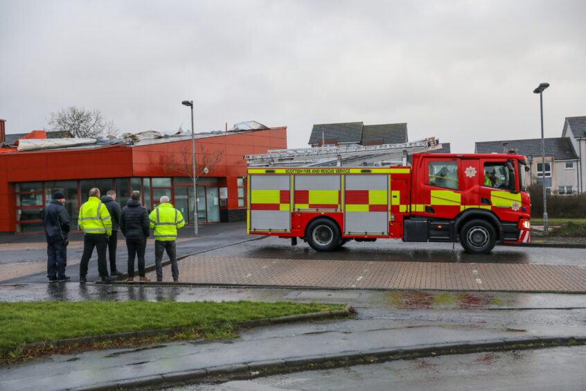 Firefighters and a fire engine outside the building