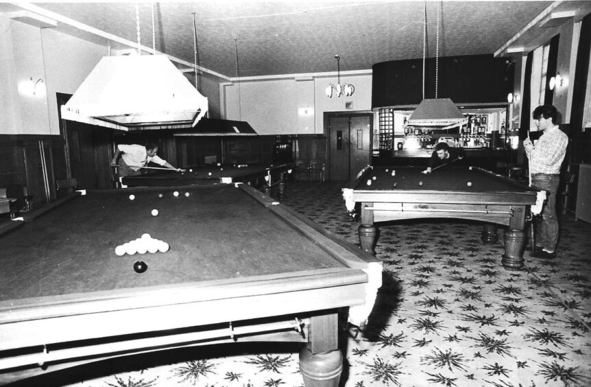 three snooker tables, with people playing