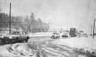 Vehicles on the snowbound Dundee to Forfar road at Petterden in January 1985.