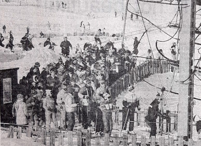 A busy scene at Glenshee during the winter of 1985, as skiiers wait for a ride on the chair lift