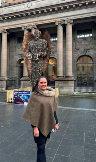 Jade Taylor standing beside Knife Angel statue in Perth