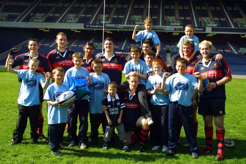 Dundee Eagles junior rugby players on the pitch with some of the Dundee High School FP team after the BT Cup final at Murrayfield in May 2004.